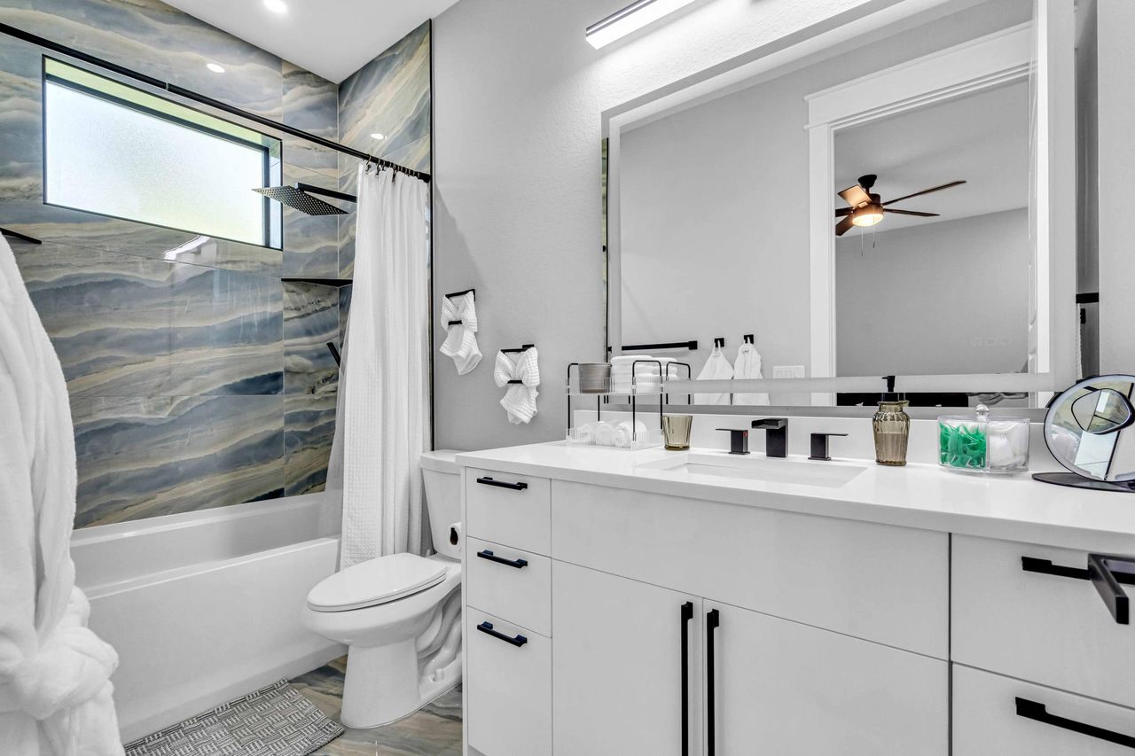 Modern marble bathroom with back-lit bathroom mirror and 2 luxury robes