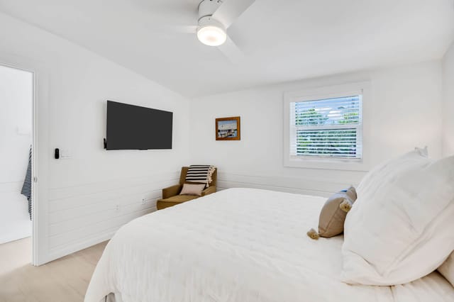 Main bedroom with ROKU TV, siting area and closet for storage.