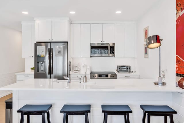 Open concept kitchen with chrome fixtures, fully equipped for all your culinary needs. Includes seating for 4 at the kit