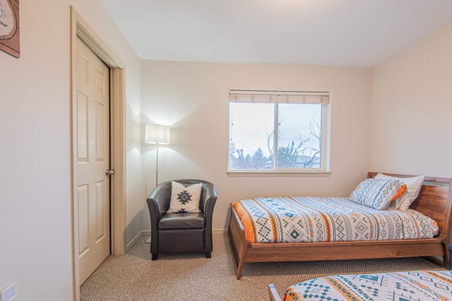 Second bedroom with twin mattresses by Avacado and walk-in closet and seating area