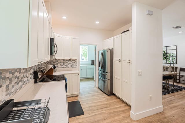 Modern kitchen with lots of free counter space for all your necessities with a view into the laundry room