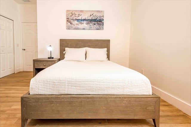 Coastal themed master bedroom with queen sized bed and high-quality bedding for relaxing on vacation time.