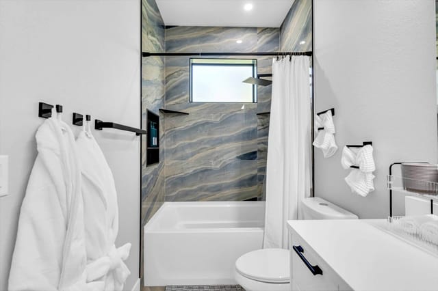 Stocked bathroom with beautiful marble walls and lots of counterspace for all your necessities