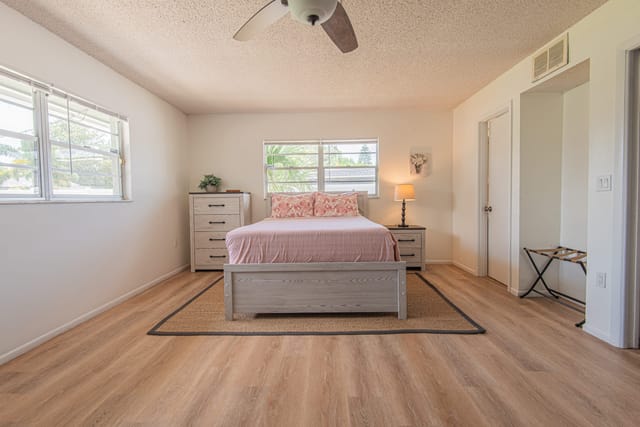 Second master bedroom with queen bed and ensuite bathroom with shower and sliding doors that open up onto the screened l