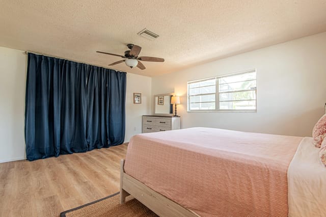 Second Master bedroom with queen size bed and dark curtains