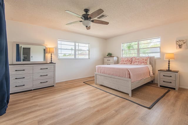 Secondary master bedroom with queen bed, ensuite bathroom with shower, and sliding doors that open up onto the screened