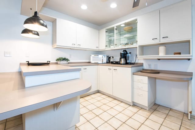 Keurig coffee pot and tea pot in well equipped kitchen, with a variety of dishes, pots and utensils, microwave, toaster,